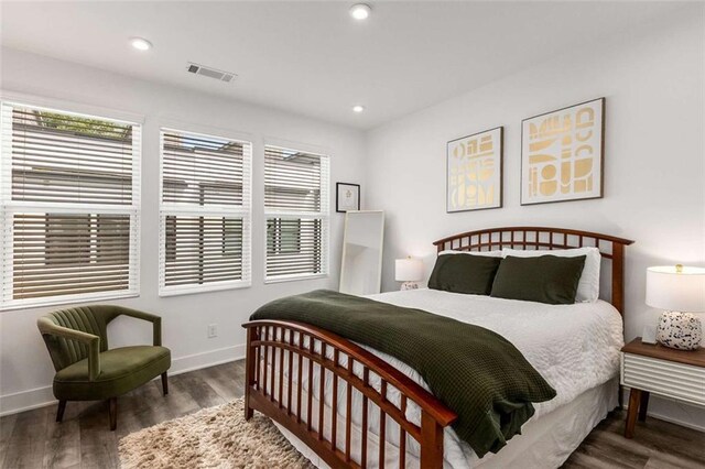 bedroom featuring baseboards, visible vents, and wood finished floors