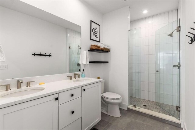 full bath featuring a sink, a stall shower, and toilet
