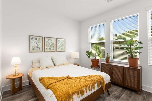 bedroom featuring baseboards, dark wood-style floors, and multiple windows