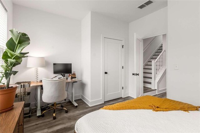 bedroom featuring visible vents, baseboards, and wood finished floors