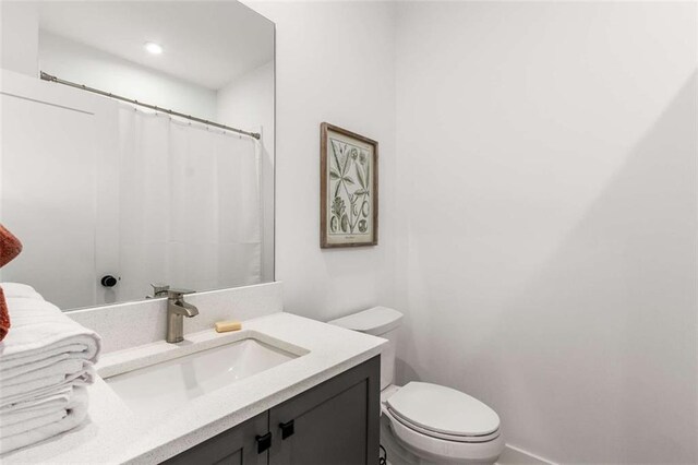 bathroom featuring vanity, toilet, and a shower with curtain
