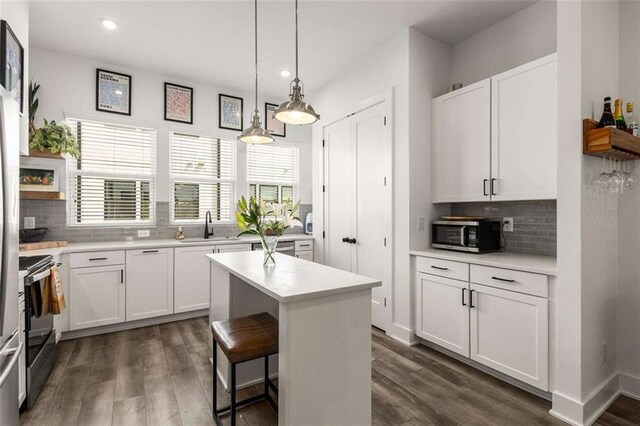 kitchen with a sink, light countertops, tasteful backsplash, and stainless steel appliances