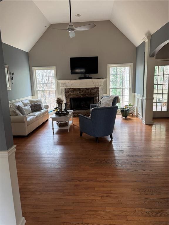 living room featuring dark hardwood / wood-style flooring, a wealth of natural light, a fireplace, and ceiling fan