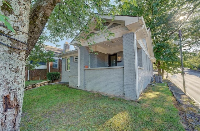 view of side of property featuring a yard and central air condition unit