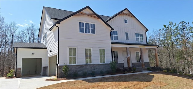 modern farmhouse style home featuring a porch, board and batten siding, concrete driveway, an attached garage, and brick siding