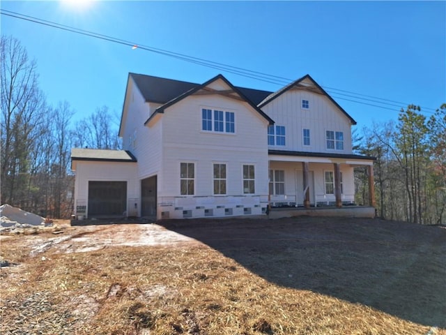 view of front facade with board and batten siding, a porch, and an attached garage