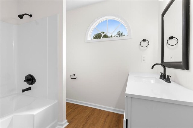 bathroom featuring hardwood / wood-style floors, vanity, and tub / shower combination