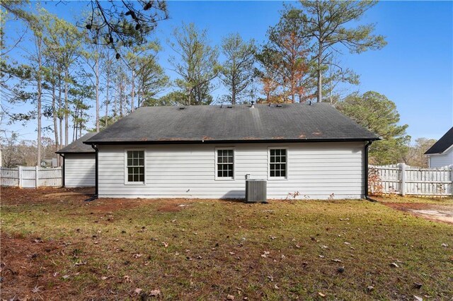 back of house featuring central AC and a lawn