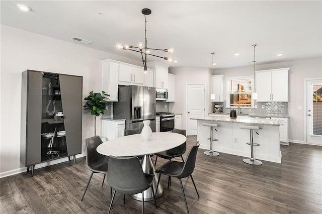 dining area featuring a notable chandelier, dark hardwood / wood-style floors, and sink