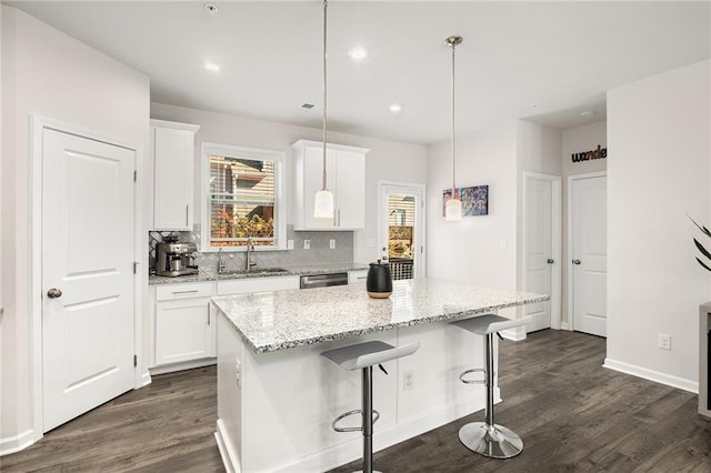 kitchen featuring a center island, pendant lighting, and white cabinets