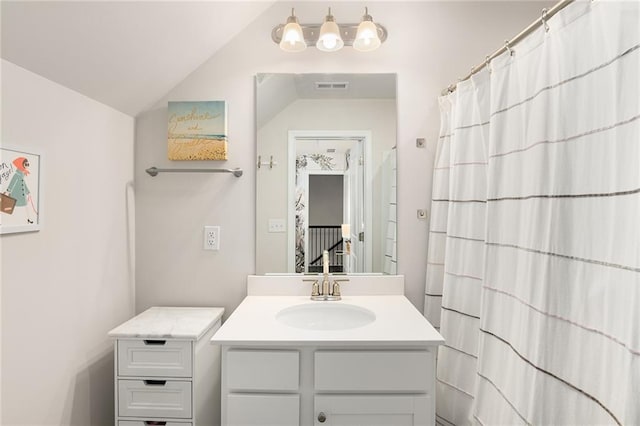 bathroom featuring vanity and lofted ceiling