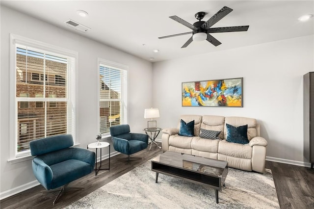 living room featuring dark wood-type flooring and ceiling fan