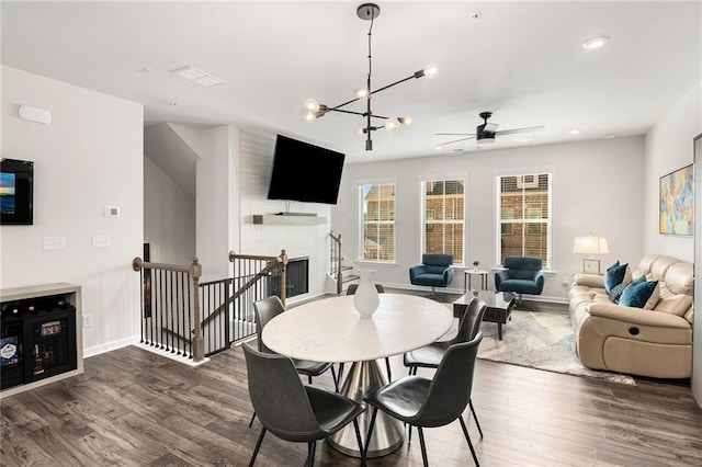 dining area featuring dark wood-type flooring and ceiling fan with notable chandelier