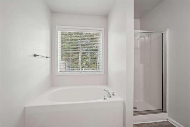 bathroom featuring separate shower and tub