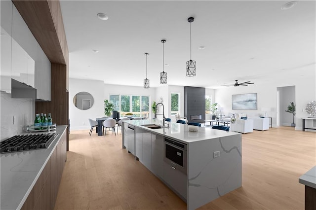 1610 Niskey Lake Rd, Atlanta, GA 30331 - kitchen featuring modern cabinets, a sink, stainless steel gas cooktop, light wood-type flooring, and recessed lighting