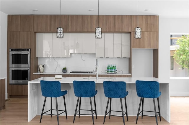 1610 Niskey Lake Rd, Atlanta, GA 30331 - kitchen with double oven, modern cabinets, light countertops, and a center island with sink