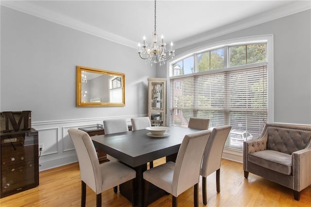 dining area with crown molding, a healthy amount of sunlight, and light wood-type flooring