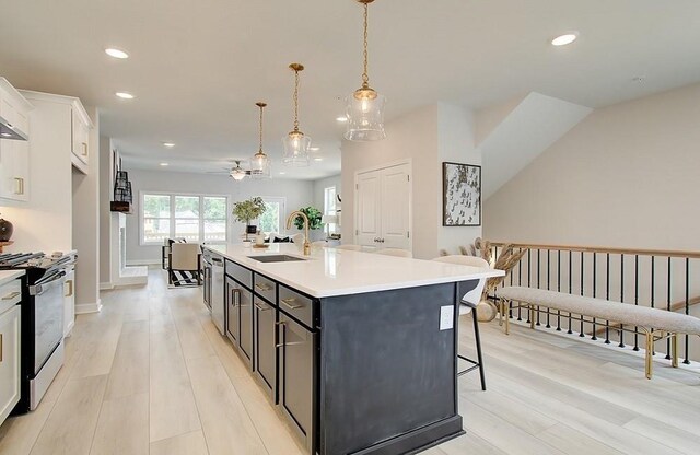 living room featuring a brick fireplace, light hardwood / wood-style floors, and ceiling fan