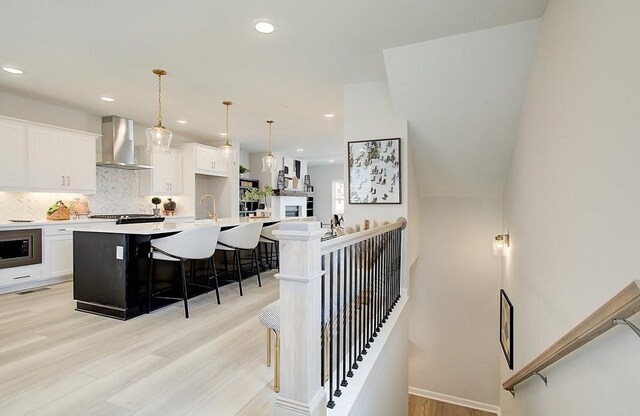 kitchen featuring sink, a chandelier, hanging light fixtures, and a center island with sink