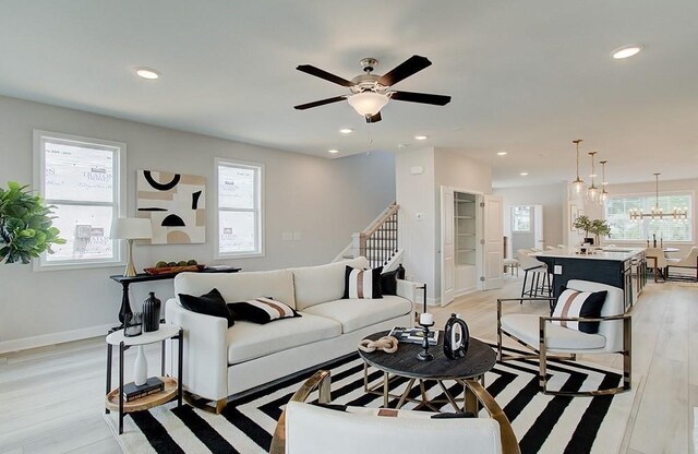 living room with a fireplace, light hardwood / wood-style floors, and ceiling fan