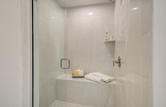 bathroom with vanity, tiled shower, and tile patterned floors