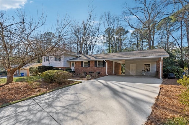 split level home with an attached carport, brick siding, and driveway