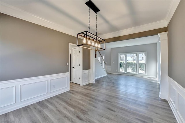 unfurnished dining area featuring ornamental molding and light wood-type flooring