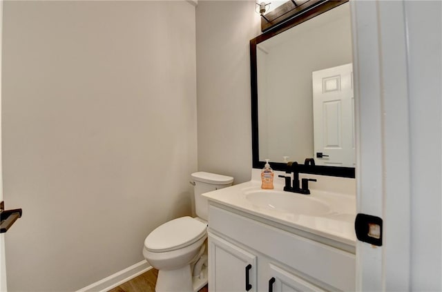 bathroom featuring hardwood / wood-style flooring, vanity, and toilet