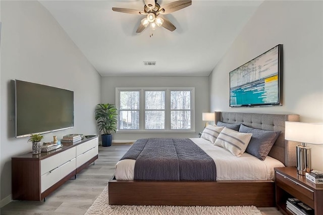 bedroom featuring ceiling fan, lofted ceiling, and light hardwood / wood-style flooring