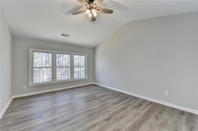 spare room featuring ceiling fan, lofted ceiling, and light hardwood / wood-style floors