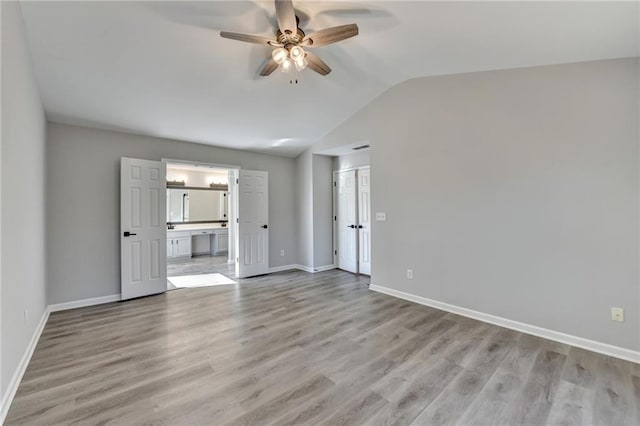 spare room with ceiling fan, lofted ceiling, and light hardwood / wood-style flooring