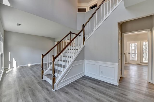 stairs featuring a towering ceiling and hardwood / wood-style floors