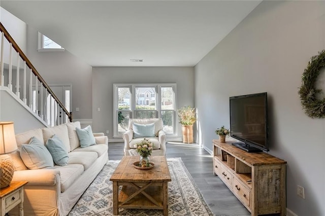 living room with dark hardwood / wood-style floors, a wealth of natural light, and a towering ceiling