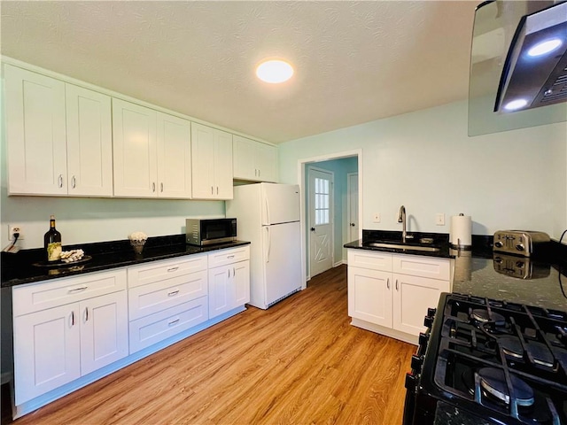 kitchen featuring black gas range, sink, white cabinets, and light hardwood / wood-style flooring