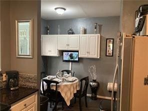 kitchen featuring white cabinets and stainless steel fridge