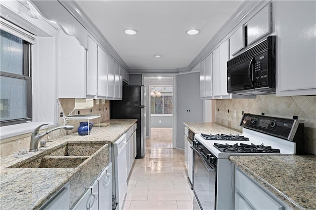 kitchen with sink, white appliances, white cabinetry, light stone counters, and decorative backsplash