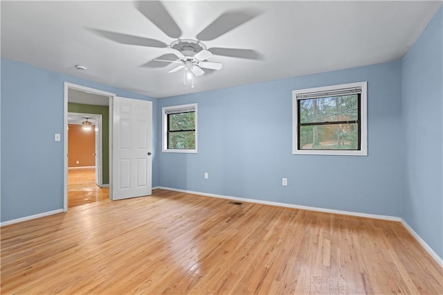 interior space featuring ceiling fan, multiple windows, and light hardwood / wood-style flooring