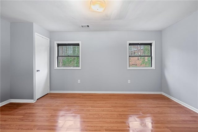 spare room featuring a healthy amount of sunlight and light hardwood / wood-style floors