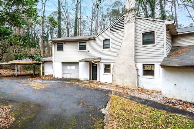 view of front of property featuring a garage and a carport