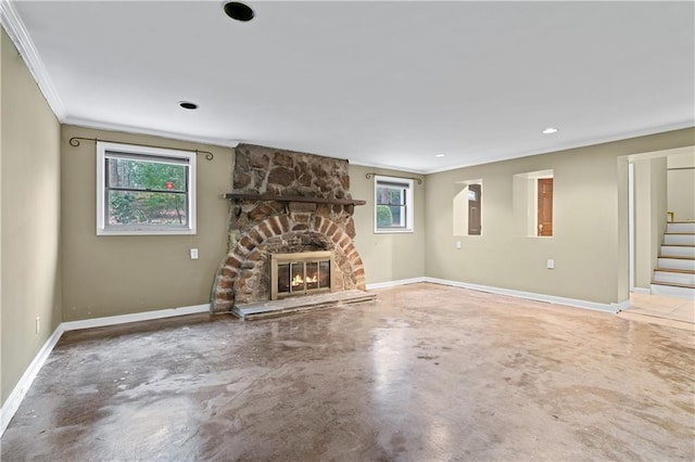 unfurnished living room with crown molding, a stone fireplace, and concrete floors