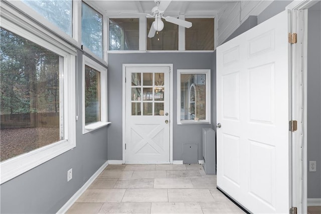 unfurnished sunroom featuring ceiling fan