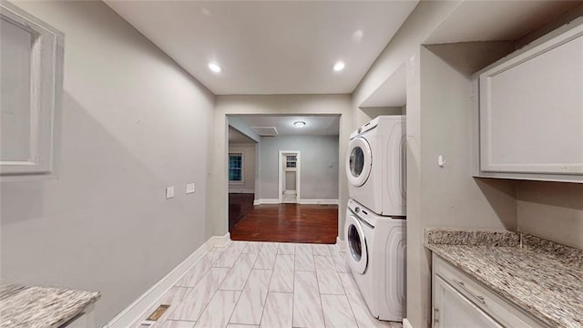 laundry room featuring estacked washer and dryer, baseboards, and recessed lighting
