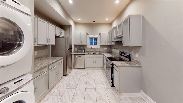 kitchen featuring stainless steel appliances, stacked washer / drying machine, a sink, under cabinet range hood, and recessed lighting