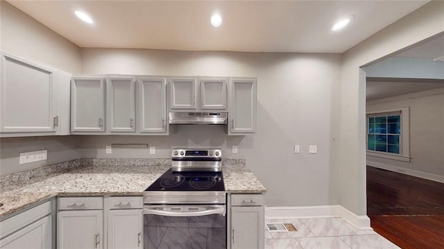 kitchen featuring electric range, under cabinet range hood, baseboards, light stone counters, and recessed lighting