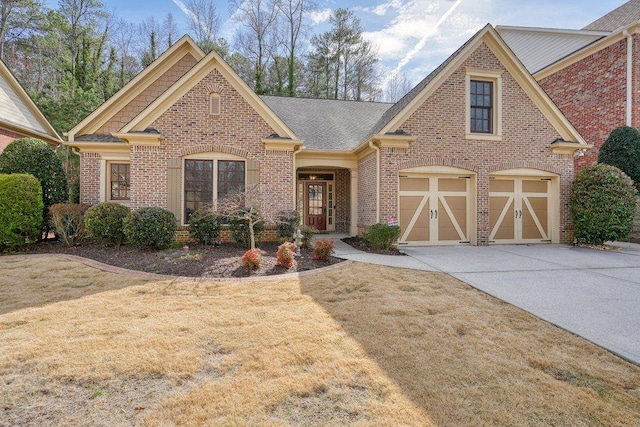 view of front of home with a front lawn, concrete driveway, and brick siding