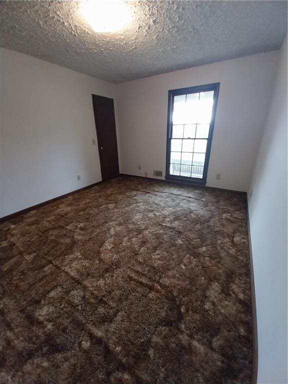6005 Hendrix Rd, Cumming, GA 30040 - carpeted empty room with a textured ceiling