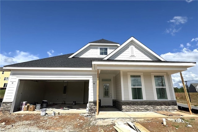 112 Kerr Dr, Hoschton, GA 30548 - view of front of property with stone siding, an attached garage, roof with shingles, and covered porch