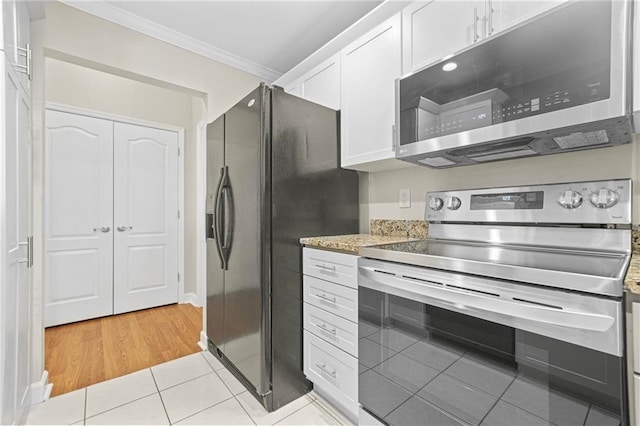 3475 Oak Valley Rd NE Unit 950, Atlanta, GA 30326 - kitchen featuring stainless steel appliances, crown molding, white cabinetry, light tile patterned floors, and light stone counters