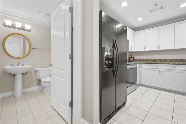 3475 Oak Valley Rd NE Unit 950, Atlanta, GA 30326 - kitchen featuring black fridge with ice dispenser, light tile patterned floors, ornamental molding, white cabinetry, and stainless steel range with electric stovetop