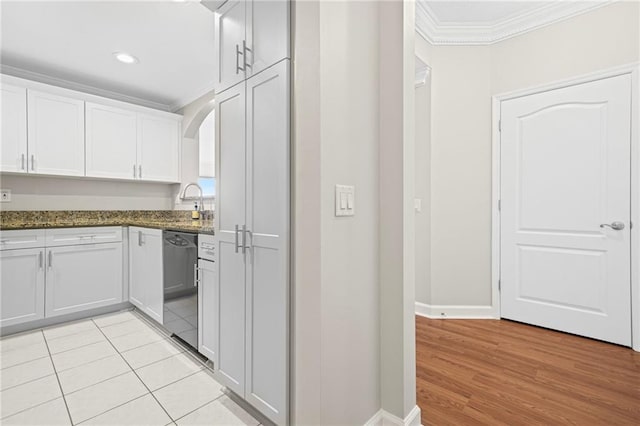 3475 Oak Valley Rd NE Unit 950, Atlanta, GA 30326 - kitchen featuring crown molding, dishwasher, white cabinets, baseboards, and dark stone counters